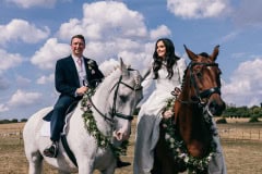 Bride and Groom riding horses.